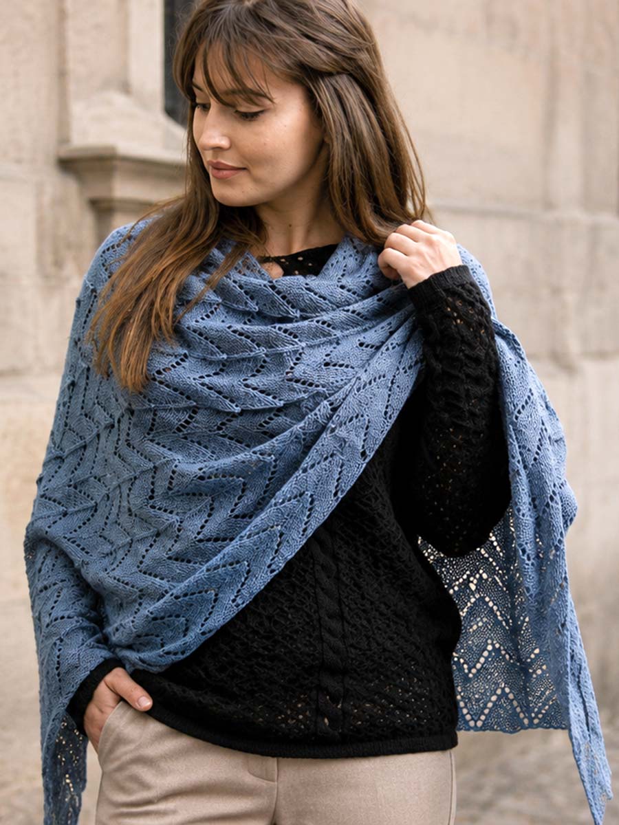 Frau mit schwarzem Lochstrickpullover und blauem Schal im Herbst